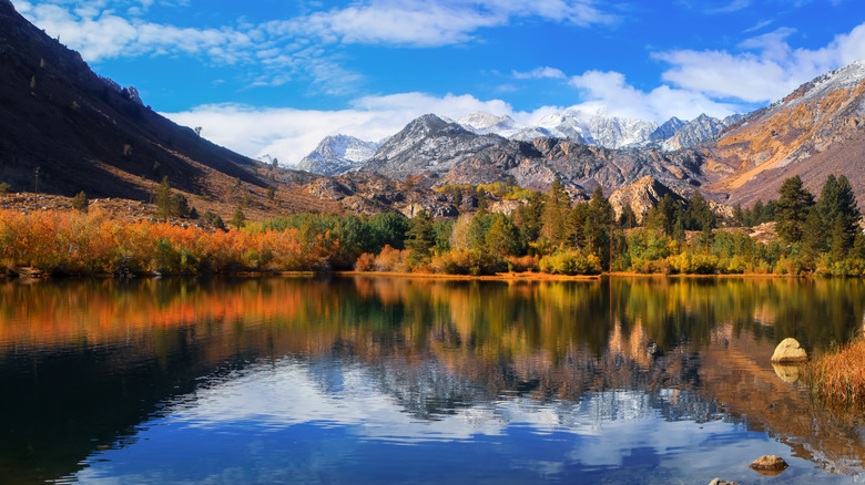 Sabrina Lake in autumn with fall foliage and mountain peaks reflected in blue waters