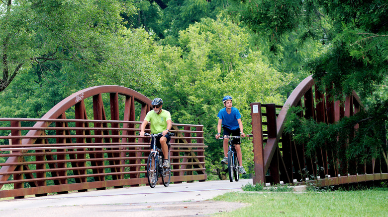 A pair of cyclists crossing a small bridge crossing through Eastwood Metropark, Dayton, Ohio