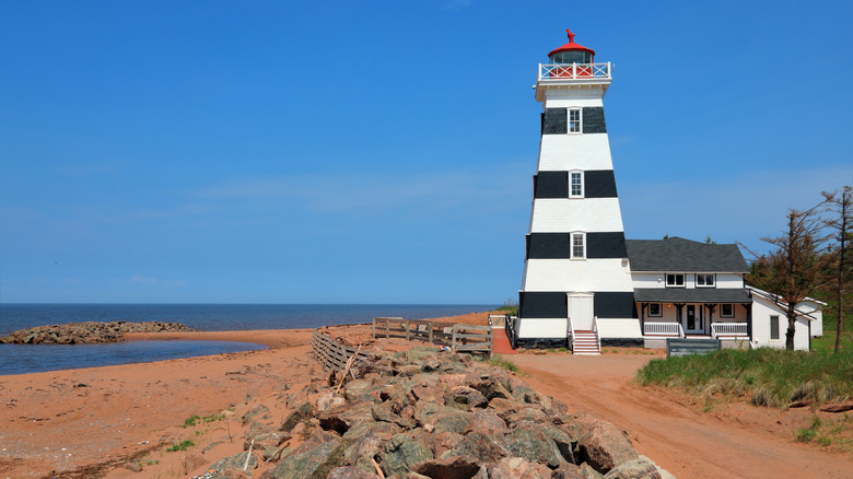 Seascape with beach and striped lighthouse