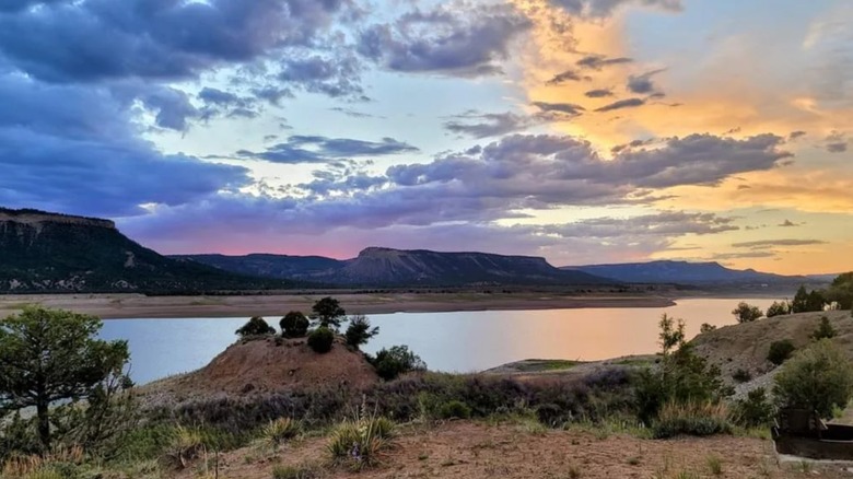 A beautiful rainbow sunset over El Vado Lake, New Mexico, with desert brush in the foreground