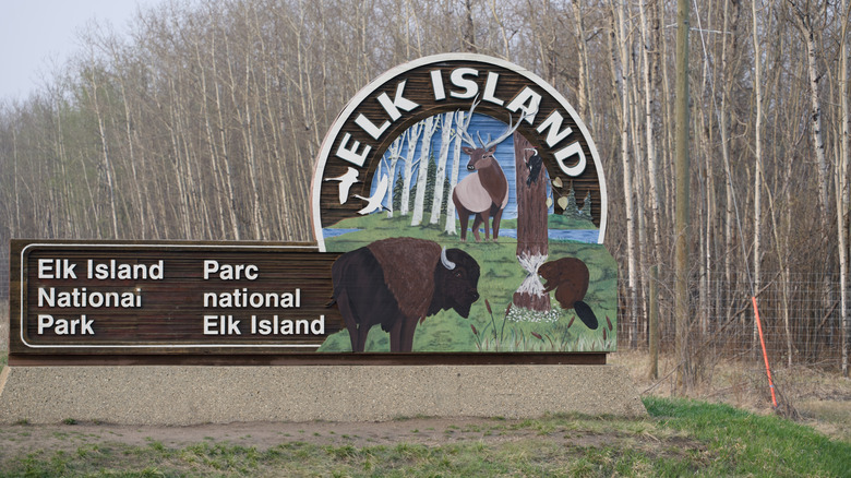 Welcome sign to Elk Island National Park with a forest behind it