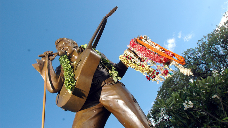 Low angle shot of the bronze Elvis statue covered in fresh leis at the Neal S. Blaisdell Center in Honolulu