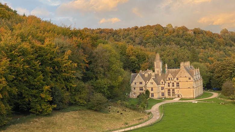 Autumnal trees surround the unfinished, honey-colored Woodchester Mansion in the Cotswolds