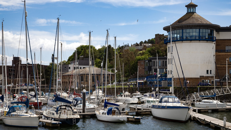 Sailboats in a busy harbour on summer day in the coastal town of Whitehaven in Cumbria