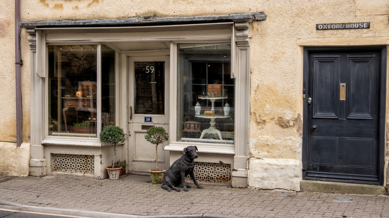 An antique shop with a dog sculpture outside in Tetbury