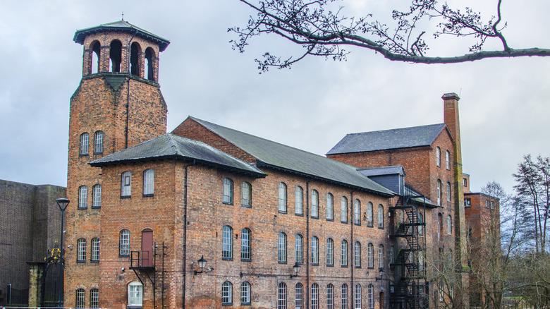 A historic, brick mill with a tower and chimney, which is now the Museum of Making in Derby
