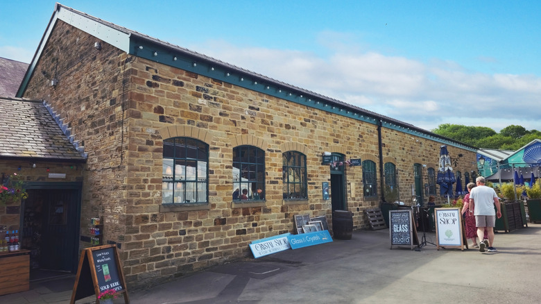 Signs advertising shops in historic brick buildings at Elsecar Heritage Center