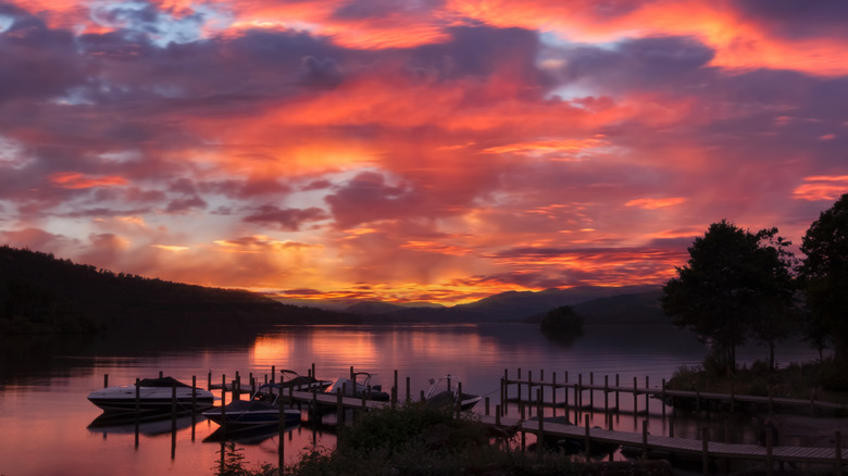 Sunset over the lake with a small pier and boats