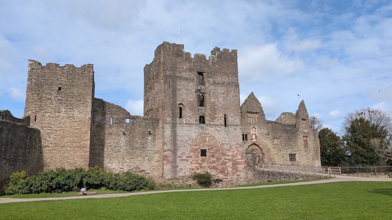 The stately Ludlow castle stands on a green field.