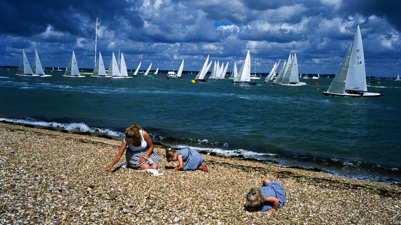 Family on Cowes beach with yachts on ocean