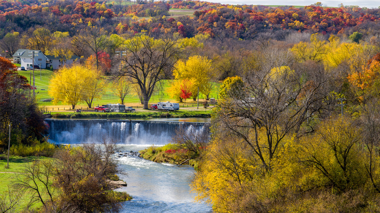 Colorful trees with fall leaves by a dam and river