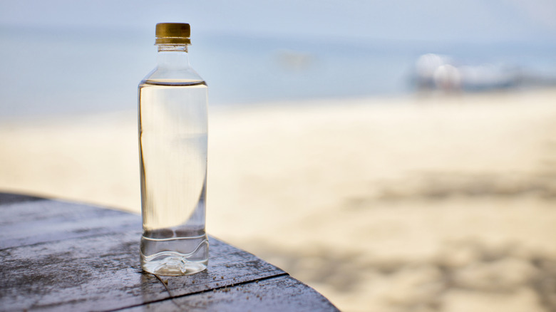 A bottle of water with a beach in the background