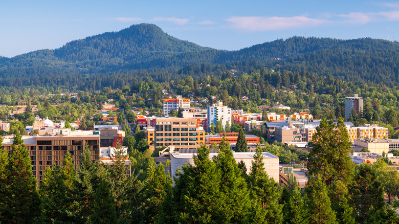 Aerial view of downtown Eugene, Oregon during the day with mountains in the background.
