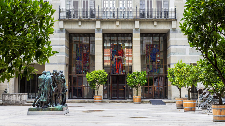 The entrance to the Kunstmuseum in Basel, with potted trees and stained glass windows