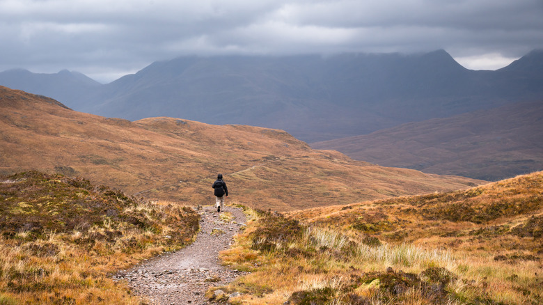 A hiker walks through the beautifully stark landscape of the West Highland Way near Kinlochleven