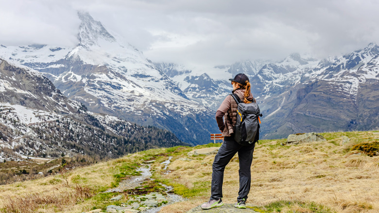 A hiker in the Valais region of Switzerland takes in the view over snow-covered Alps