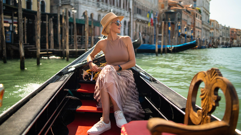 A woman sitting on a gondola in Venice, Italy