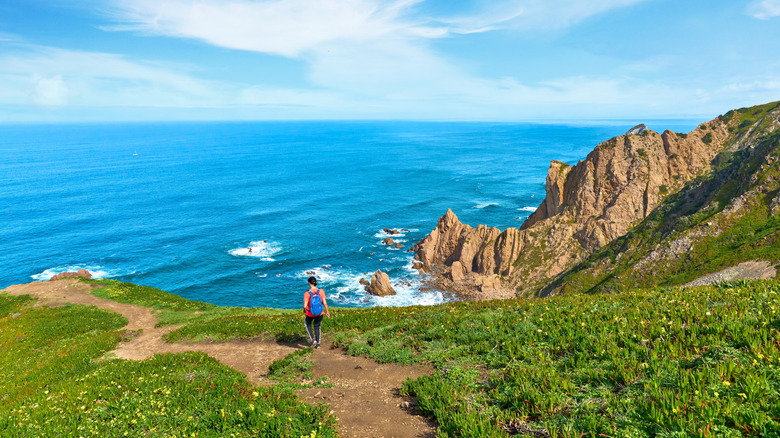 A woman hiking along the coastal cliffs of Portugal