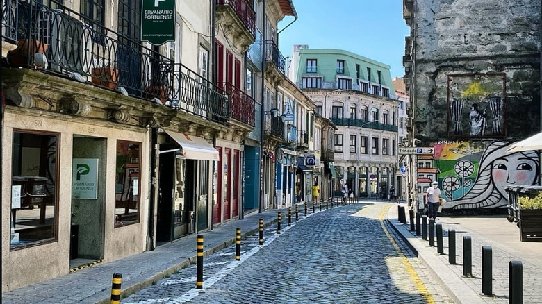 Street art and cobblestones on Rua do Bonjardim in Porto