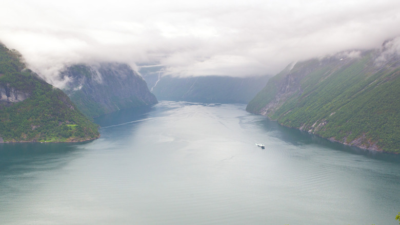 Cloudy day at Hornindalsvatnet in Norway, with a person boating in the water while surrounded by mountains