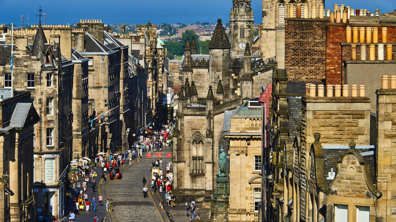 High-up view of Edinburgh's Royal Mile lined with historic brown and tan buildings, and pedestrians walking
