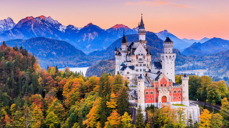 neuschwanstein castle set against a mountainous horizon at sunset