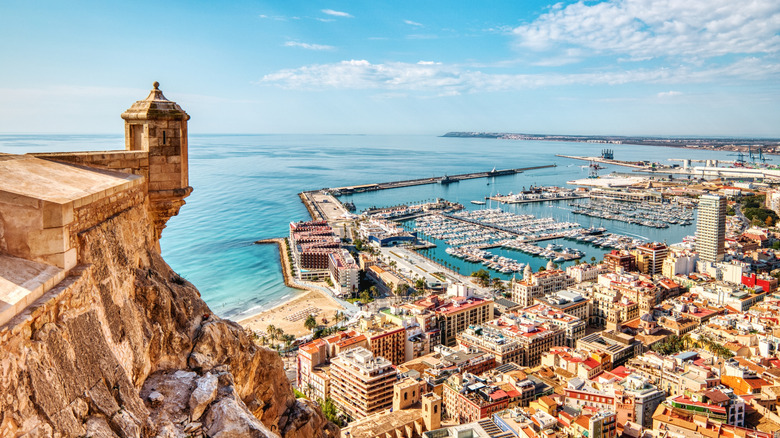 Castle ramparts overlooking a port, beach, and town center