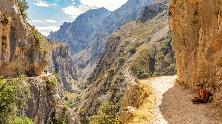 A man resting in the shade along the route, surrounded by breathtaking canyon views.