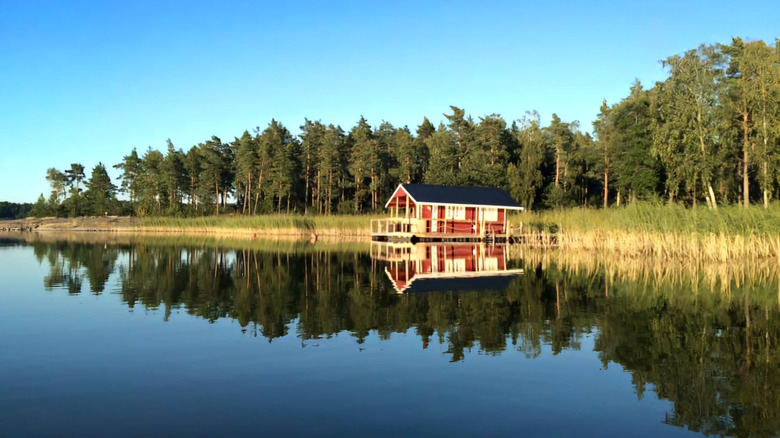 Small red house overlooking a serene lake in Archipelago National Park, Nagu