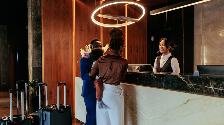 a family checks out at hotel reception