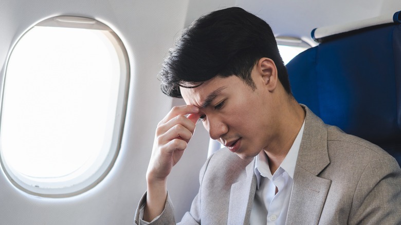 An annoyed, confused passenger on an airplane