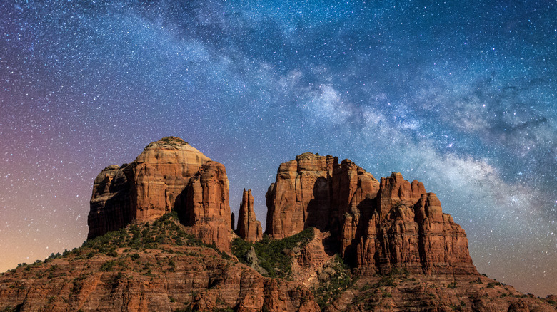Red rock buttes against a starry night sky