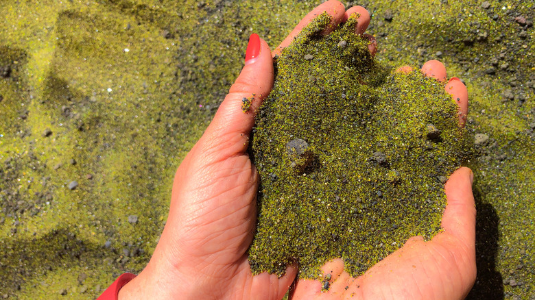 Woman holds handful of sand