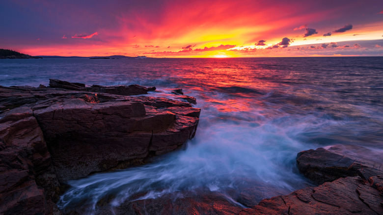 Sunset over the rocky shore with waves in Acadia National Park