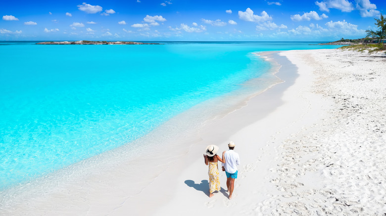 A couple walking on the beach in Exuma, Bahamas