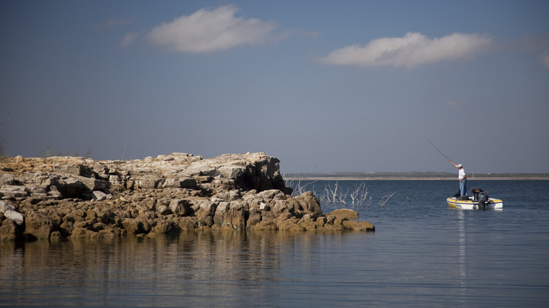 Man fishing from a boat near the shore on Falcon Lake in Texas