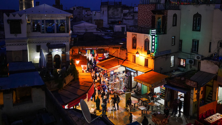 Elevated night view of street in Fes, Morocco, as pedestrians fill lamplit street