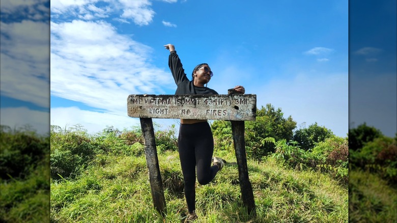 Woman at the sign for Mount Tomaniivi