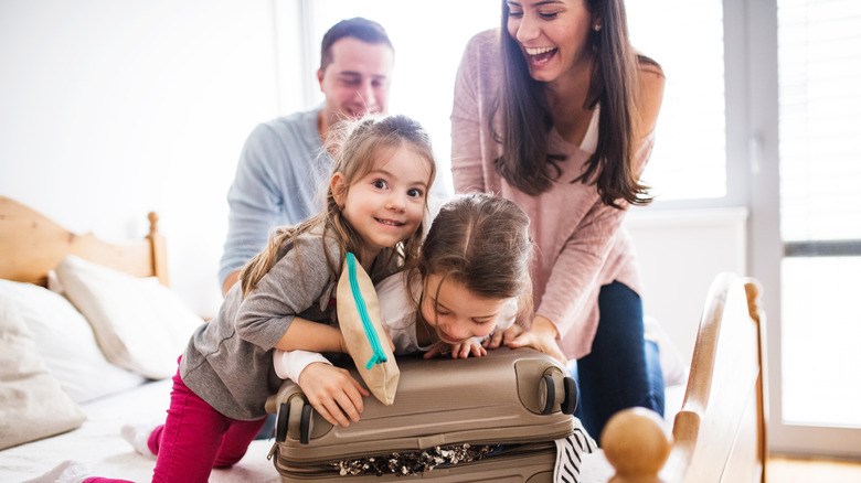 Family with children packing their suitcase