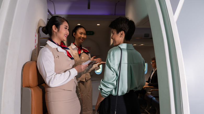 flight attendants welcome passenger on board