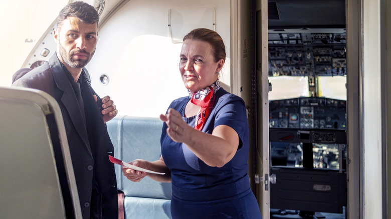 stewardess welcomes a passenger onboard an airplane