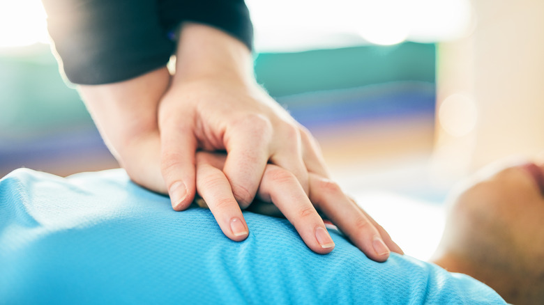 hands performing CPR chest compressions
