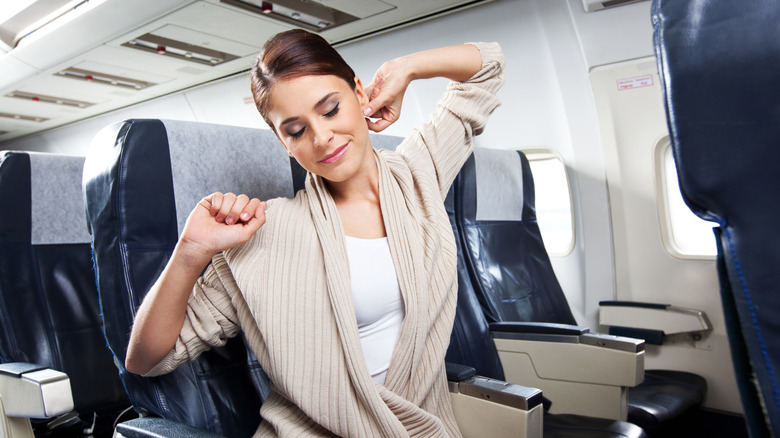 A young woman stretching during her flight