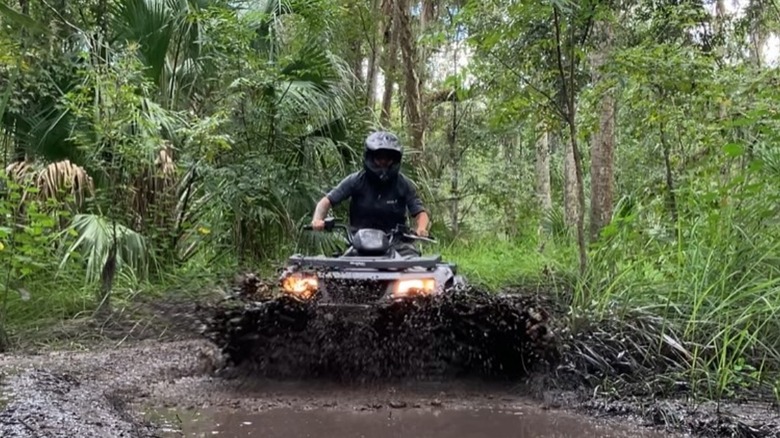An ATV rider in mud at Peace River in Central Florida