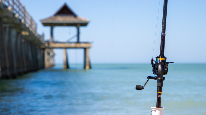 Fishing pole beside the water with a dock on the side