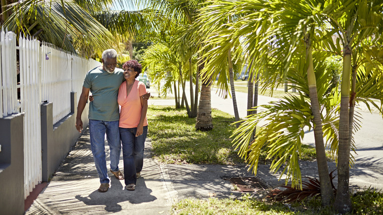 Retirees walking on palm-lined street