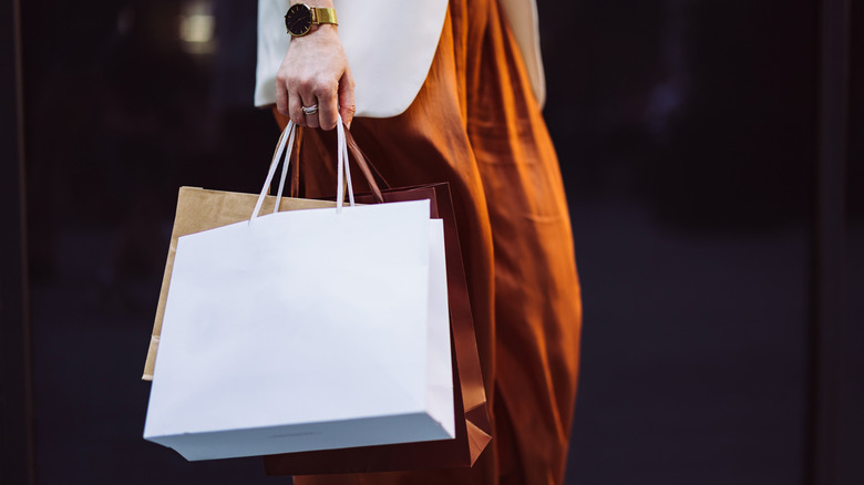 A woman carrying shopping bags from different boutiques.
