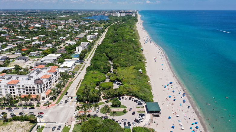 Aerial photo of Boca Raton Beach with beachfront hotels and businesses on left and bright blue water on right