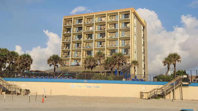 View of Sun Viking Lodge hotel tower from the property's private beach on a sunny day