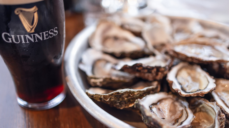 Close-up view of oysters and beer on wooden table